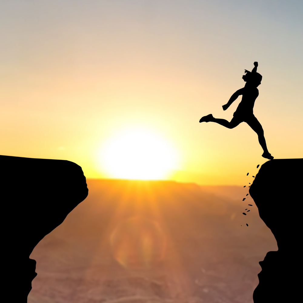 Person leaping across a gap at sunset, symbolising courage and life transitions